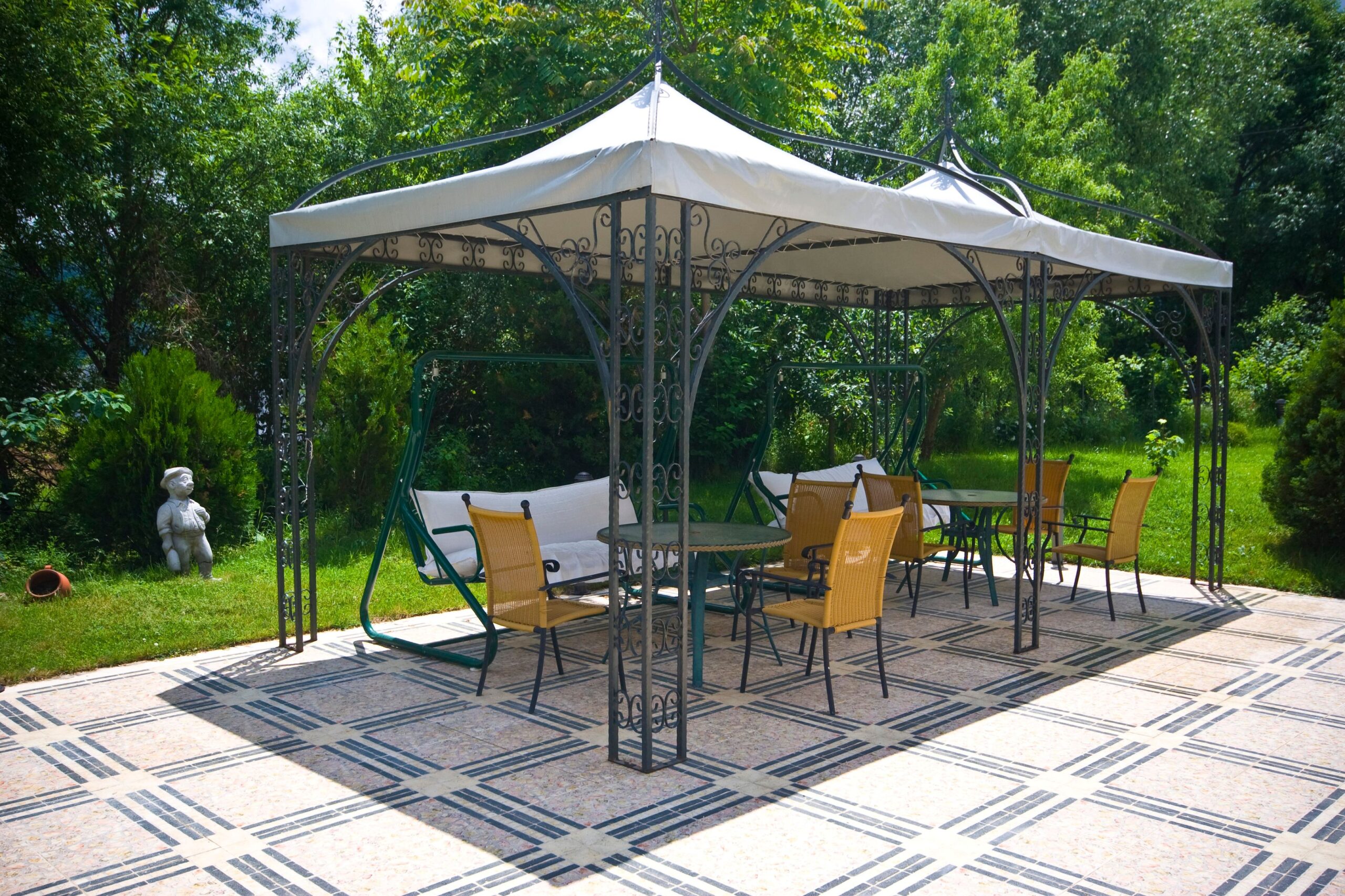 Gartenzelt mit Metallgestell und hellen Dachplanen auf gepflasterter Terrasse
