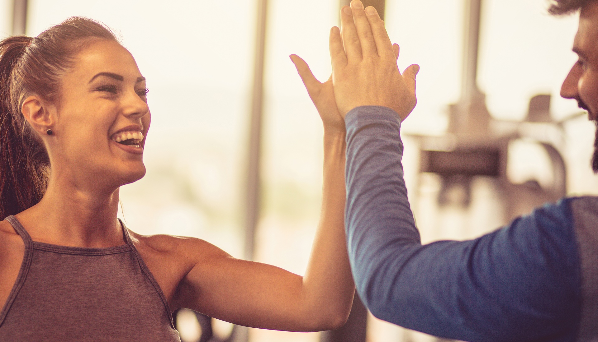 Sportler geben sich im Fitnessstudio High Five | Hausarzt Erlangen